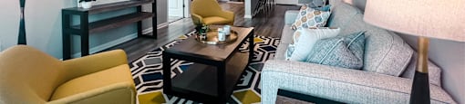 A living room with a yellow chair and a grey couch.
