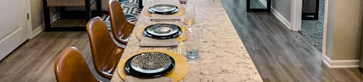 A dining room with a long table set for a meal.