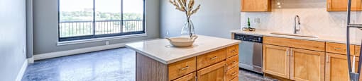 A kitchen with wooden cabinets and a countertop with a vase of flowers on it.