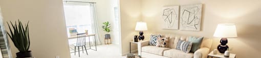 A living room with a couch, chair, and two lamps.
