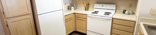 A kitchen with wooden cabinets and white appliances.
