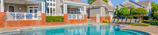A house with a pool in front of it.