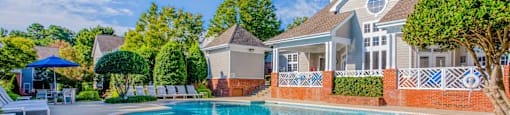 A house with a pool in front of it.