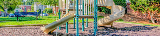 A playground with a slide and a climbing frame.