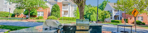 A blue dumpster sits in the foreground of a residential street.
