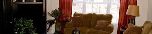 A living room with a black cabinet, brown couch, and a glass coffee table.