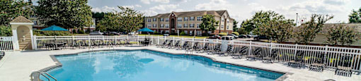 A large outdoor swimming pool with a diving board and a slide.