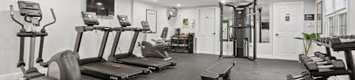 A spacious gym with treadmills, elliptical machines, and other exercise equipment.