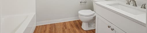 A white bathroom with a toilet, sink, and a shower.