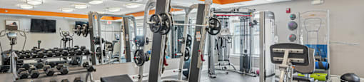 A gym with a variety of equipment including weights and machines.