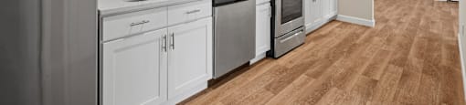 A modern kitchen with white cabinets and stainless steel appliances.