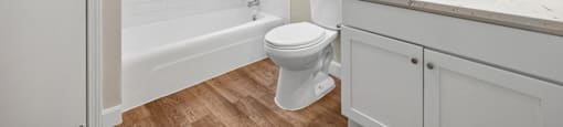 A white bathroom with a toilet, sink, and bathtub.