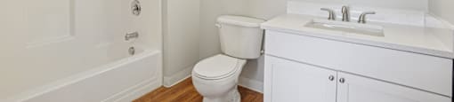 A white bathroom with a toilet, sink, and bathtub.