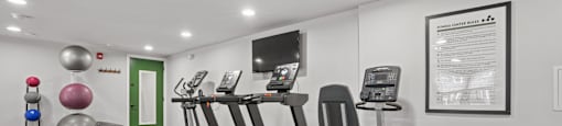 A gym with treadmills, exercise bikes, and weight training equipment.