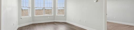 A room with wooden floors and a large window.