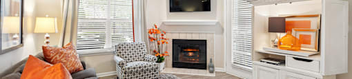 A living room with a fireplace and a television.