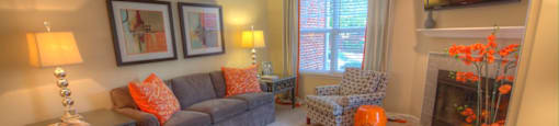 A living room with a grey couch, a fireplace, and a television.