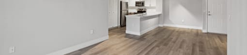 A room with wooden flooring and white walls.