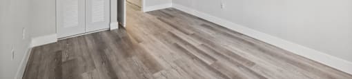 A room with a white door and a wooden floor.