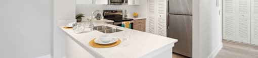 A kitchen with white cabinets and a white island.