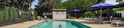 A pool with a blue tile border and a diving board.
