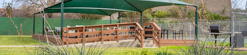 a gazebo in a park with benches and a table under it