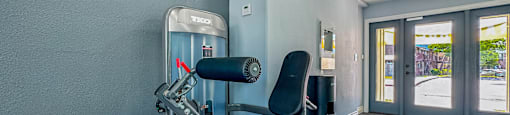 A gym room with a treadmill and a chair.