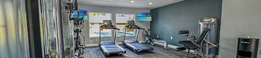 A gym with treadmills, elliptical machines, and other exercise equipment.