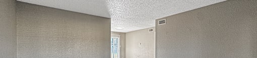 A spacious room with tile flooring and beige walls.