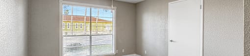 Empty room with a window and a ceiling fan.