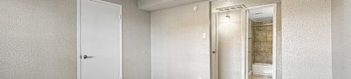 A room with a white ceiling fan and a door on the left.
