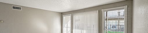 A room with a tiled floor and a window with blinds.