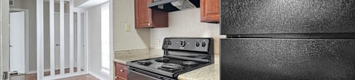 A black refrigerator is in a kitchen with wood cabinets.