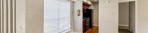 A room with wooden floors and a small kitchenette.