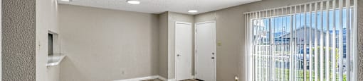 A room with tile flooring and a sliding glass door.