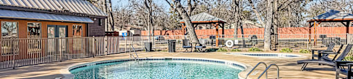 A round above ground pool with a metal fence around it.