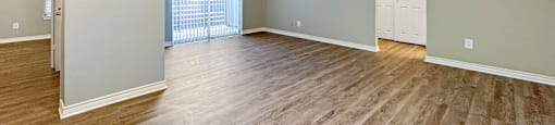 A room with light wood flooring and a white door.