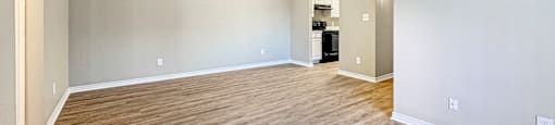 A spacious room with wooden flooring and a white ceiling.