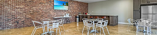 A room with a brick wall and a television mounted on it.