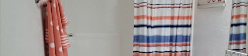 A white bathroom with a towel hanging on the wall.