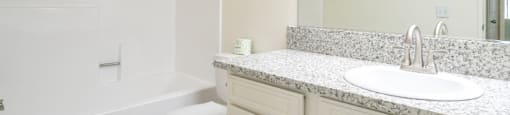 A white bathroom with a sink, toilet and bathtub.