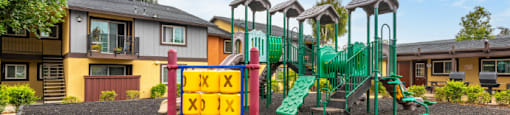 A playground with a sign that says "Kids Play Area" in front of a building.