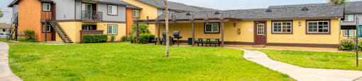 A row of houses with a green lawn in front.