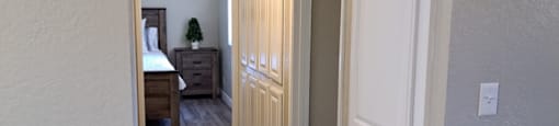 A hallway with a bedroom at the end.