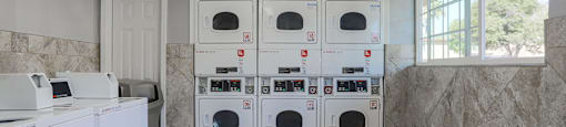 Laundry Center with Machines Next to Folding Counter at Dover Park Apartments, Fairfield, CA, 94533