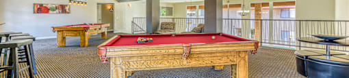 A room with a pool table and a billiard table.