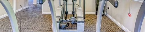 A treadmill and a stationary bike are in a gym.