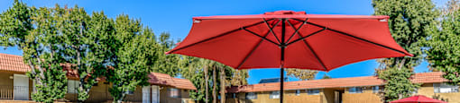 A patio with a table and chairs and an umbrella.