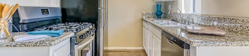 A kitchen with a black fridge, stove, and oven.