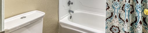 A white bathtub with a shower curtain in a bathroom.